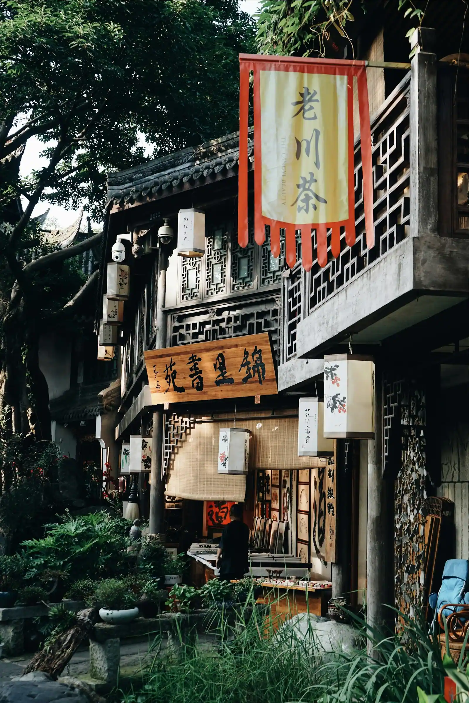 The side of a building hung with layers of shop signs and plants