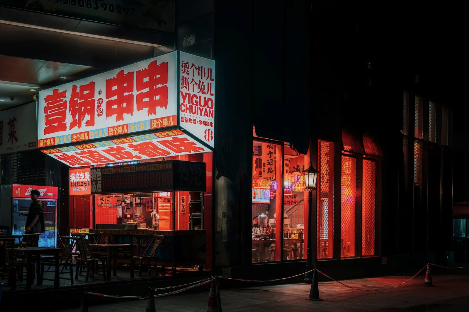 A skewer restaurant at night, its white-and-red sign glowing against the dark street