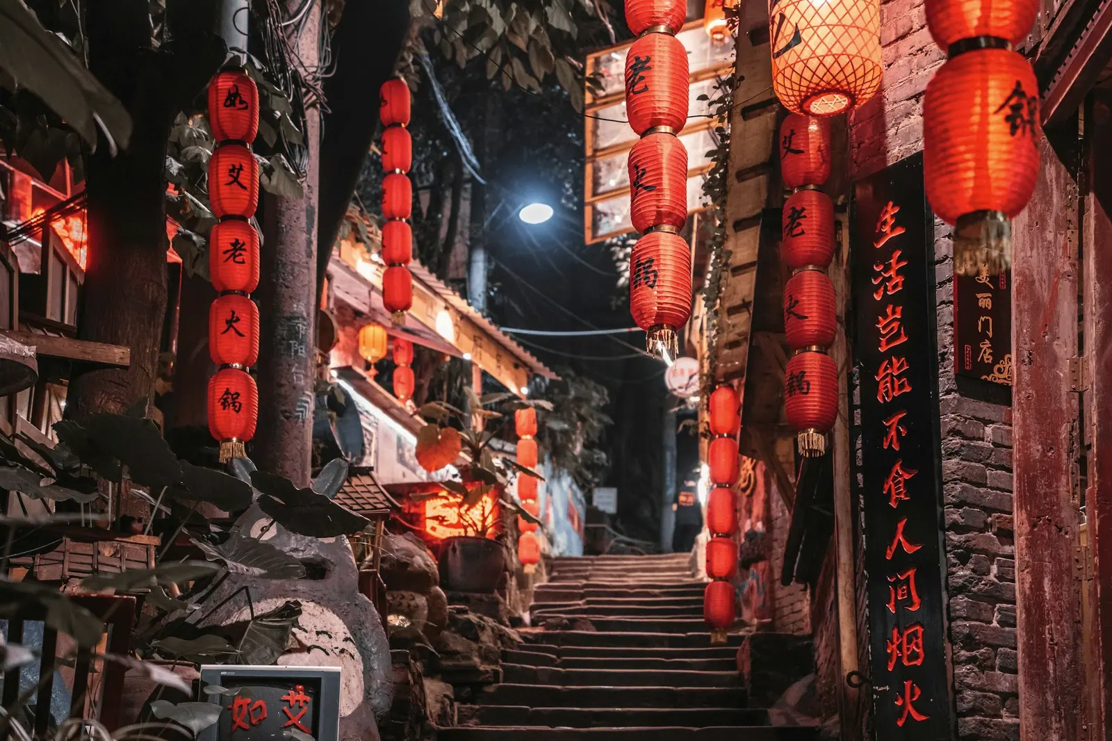 A stone-stepped old lane hung with red lanterns, wooden shopfronts on both sides
