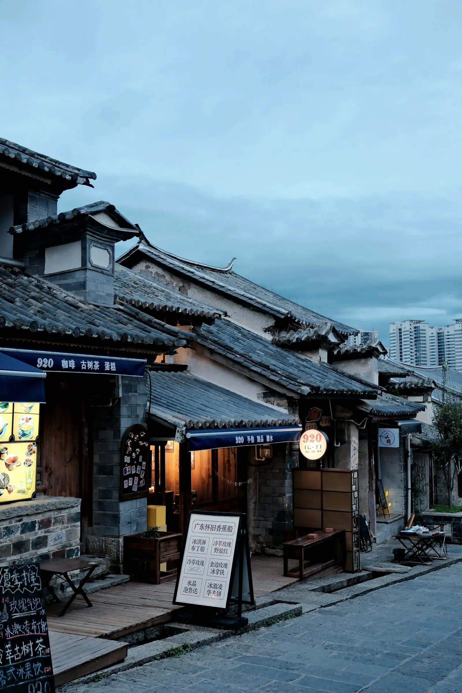 Stone houses along a narrow street, lights coming on in the blue hour