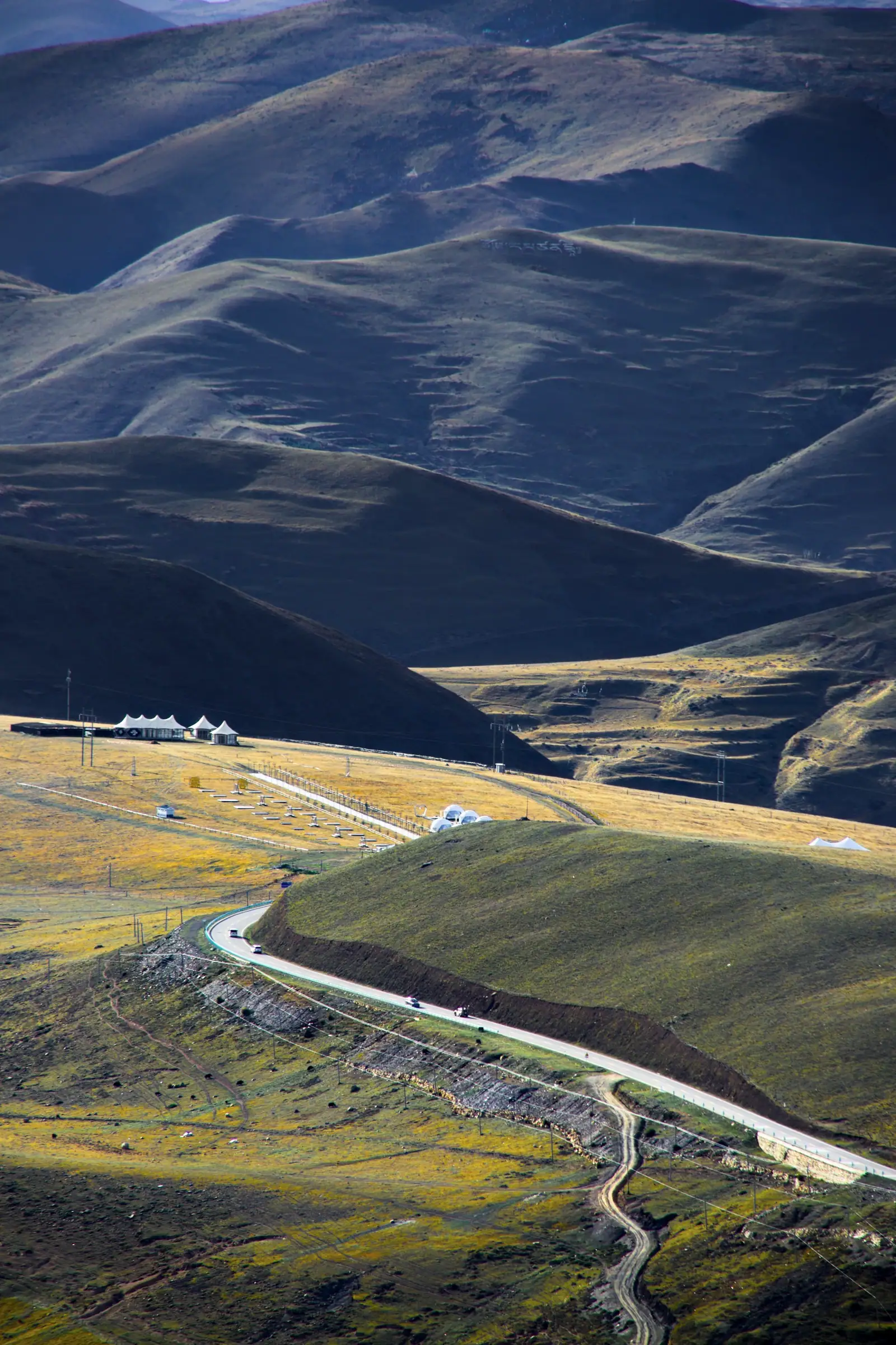 A switchbacking road crossing rolling hillsides